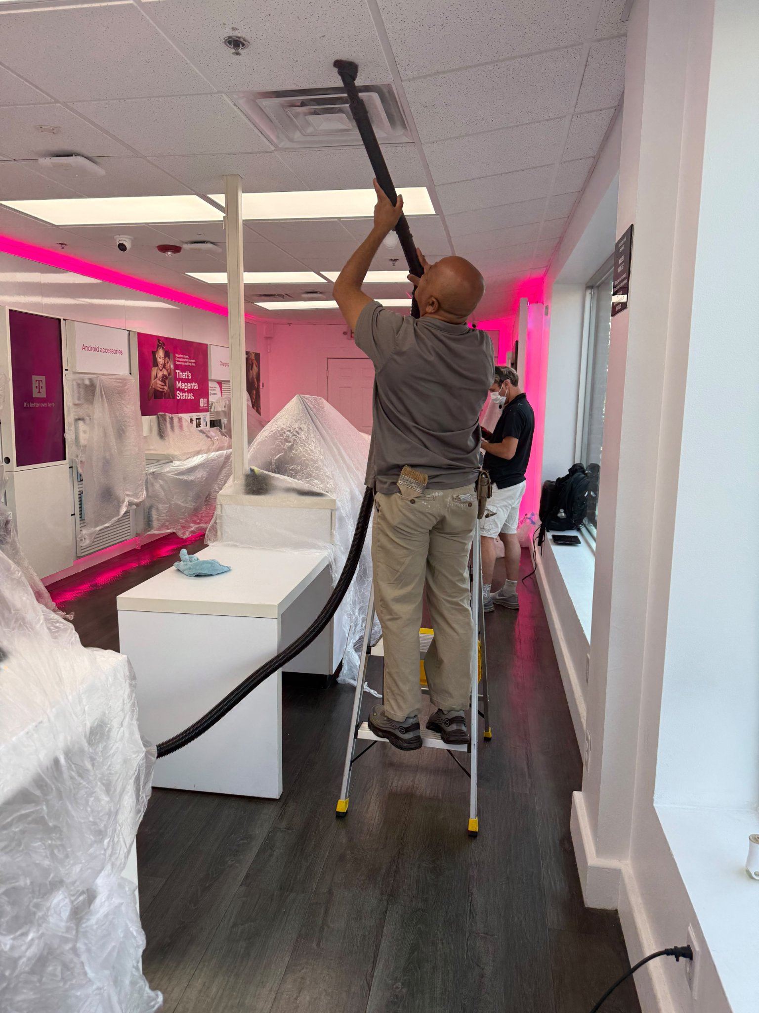 Technician cleaning a vent inside a T-Mobile store