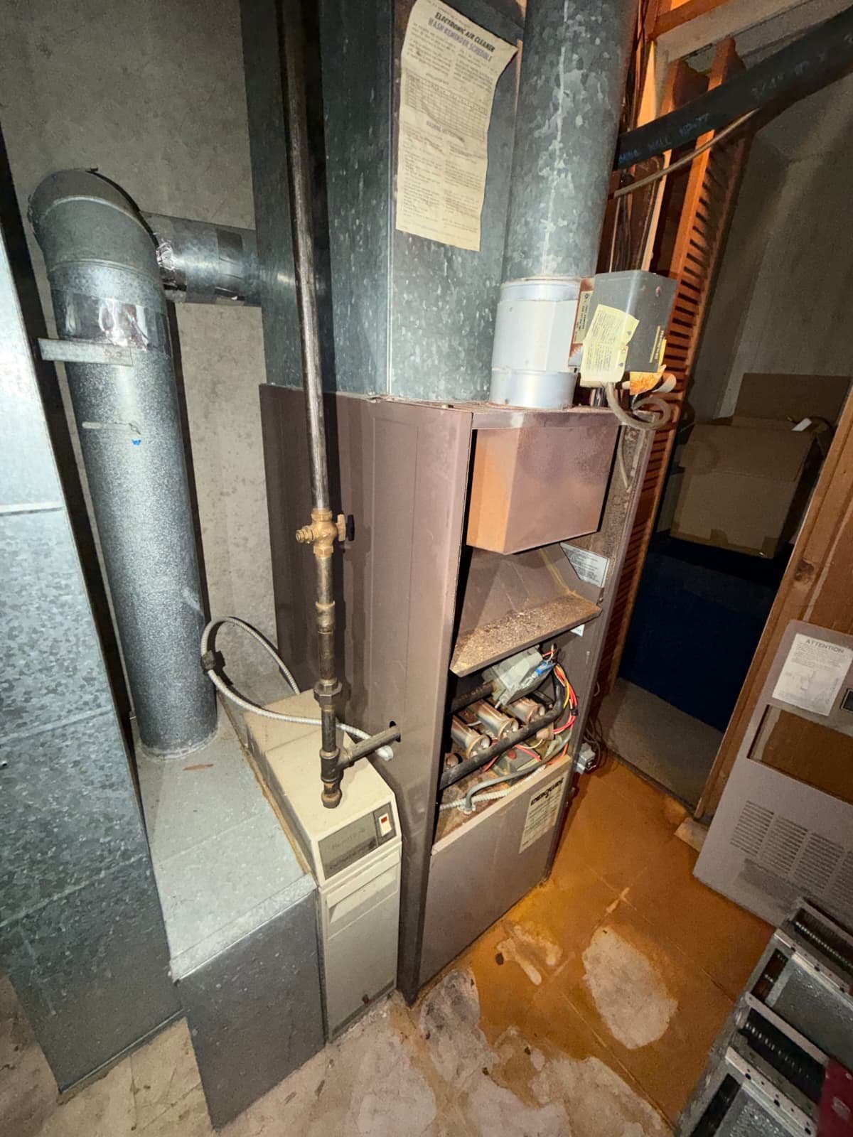 Old rusted furnace before replacement in a flip house