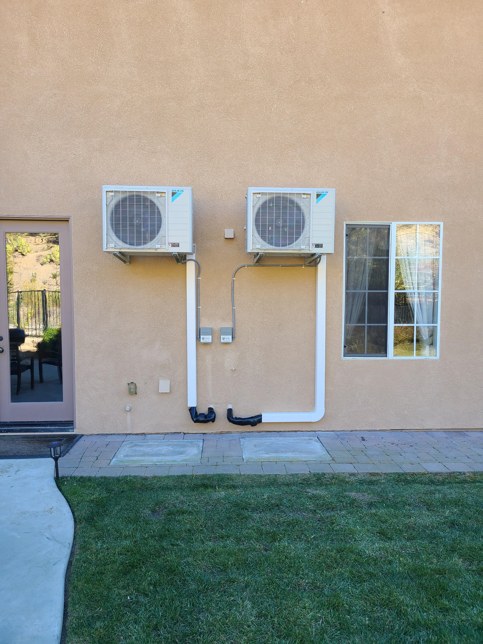 Dual Daikin mini-split units wall-mounted with line-set covers