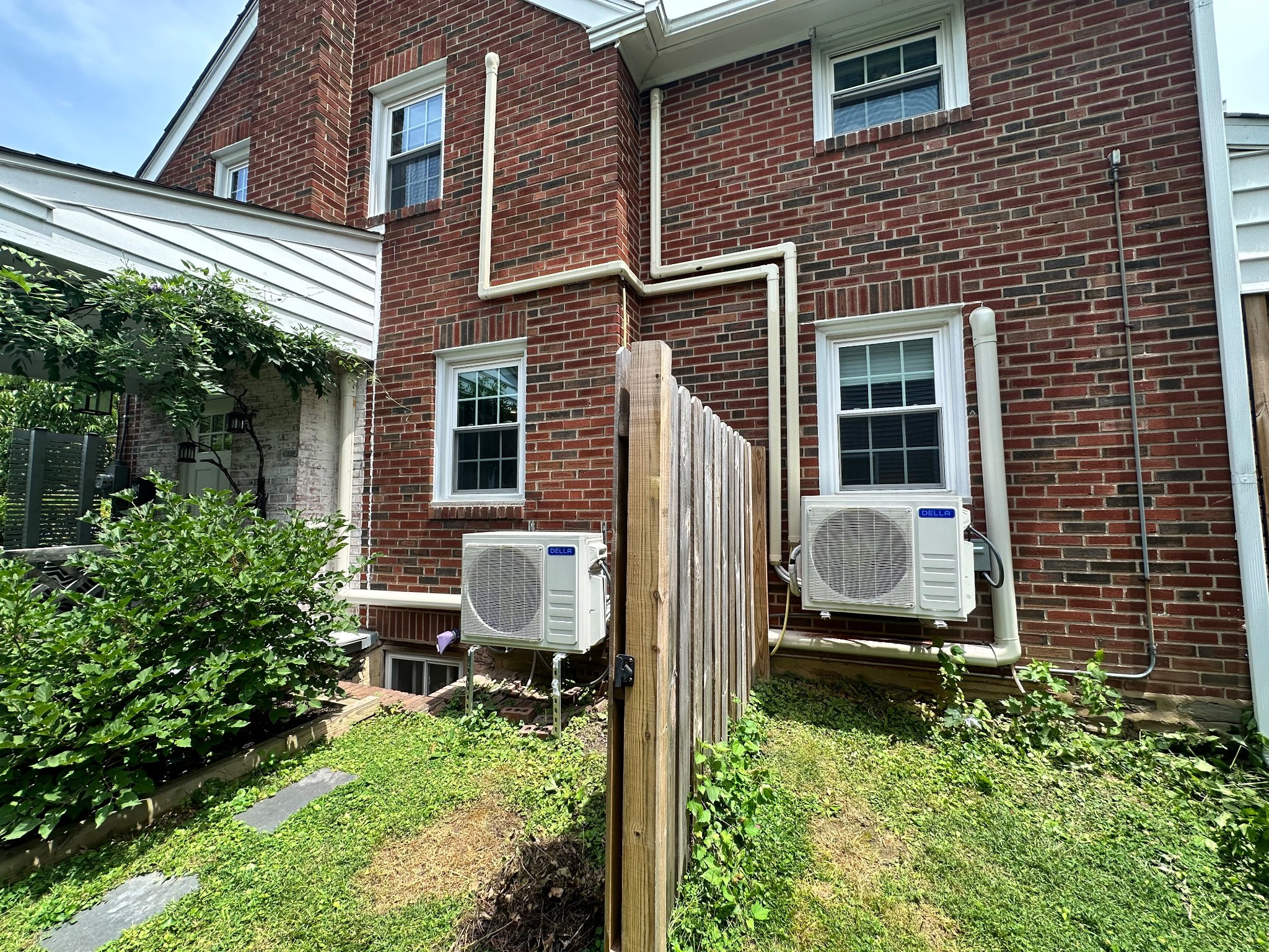 Dual DELLA mini-split outdoor units installed on a brick home
