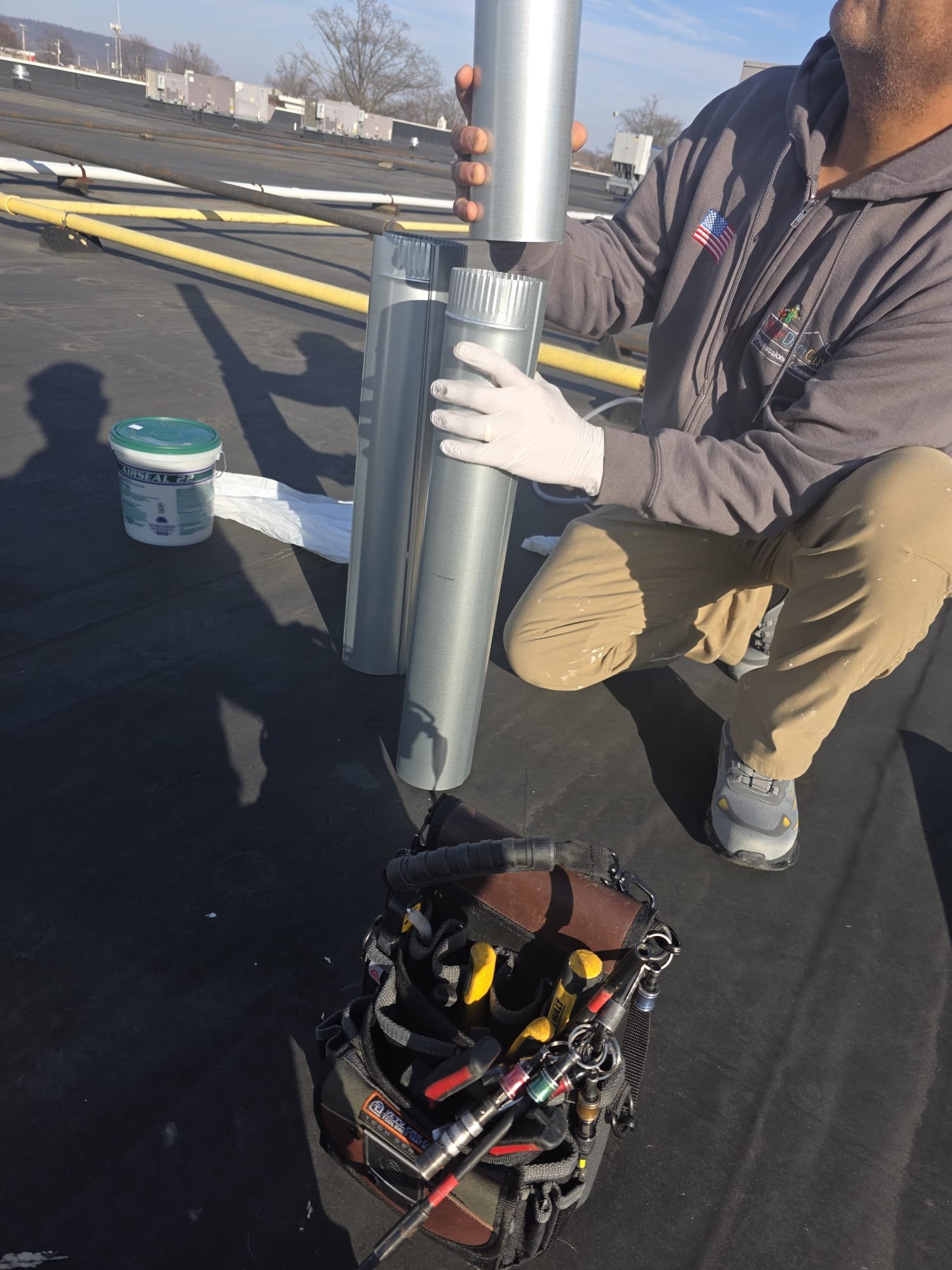 Technician Fitting A Rooftop Dryer Vent Pipe